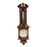 A late Victorian oak wall barometer by Negretti & Zambra, with a carved architectural case with a