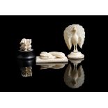 Three ivory carvings, depicting a coiled snake on a rectangular plinth base, an erect peacock, and