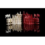 λ A late 19th century Chinese export carved ivory chess set, natural and stained red, with foliate