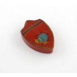 A 19th century tole peinte snuff box, shield form, the hinged cover with a harvest trophy and '