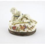 A Mennecy porcelain silver-mounted snuff box and cover, c.1740, modelled as a reclining shepherd,