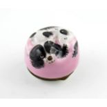 A Bilston enamel bonbonniθre, c.1770, modelled as a black and white spaniel curled up on a pink