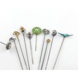 A collection of ten hat pins, comprising: a 9 carat gold example by Charles Horner, a silver and
