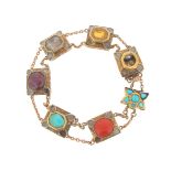 An Indian gem-set gold bracelet, the rectangular panels are set with coral, turquoise, a ruby, a