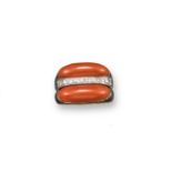 A coral and diamond dress ring, of abstract design and set with two coral cabochons, set either side