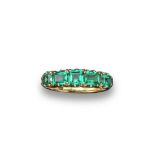 A Victorian five stone emerald half hoop ring, set with five graduated square shaped emeralds in a