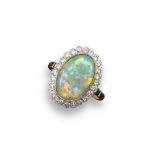 An opal and diamond cluster ring, the solid white opal cabochon is millegrain-set within a