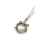 A pearl and diamond foliate pendant, the hollow pearl is set within foliate silver and gold