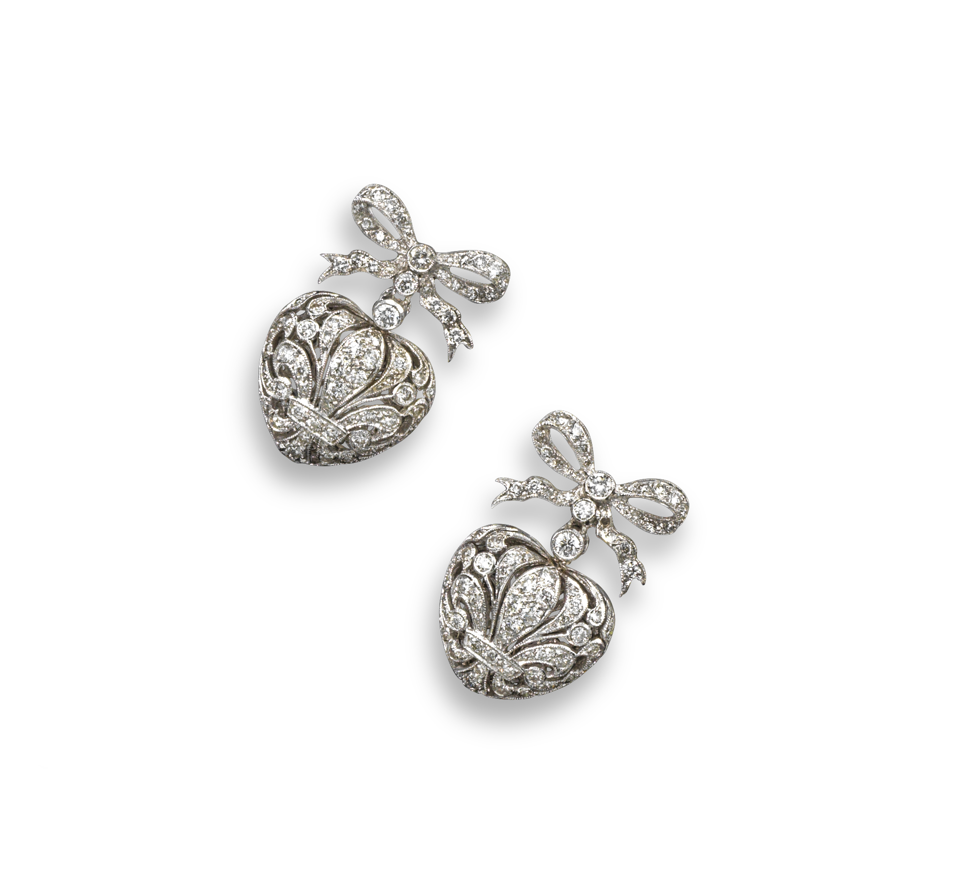 A pair of diamond set white gold heart-shaped drop earrings, the hearts are pierced with foliate