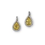 A pair of fancy yellow and white diamond drop earrings, each earring is centred with a pear-shaped