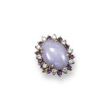 An oval shaped jade cabochon mounted gold ring, the lilac coloured jade is alternately set within