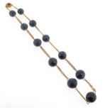 A mid 19th century lapis lazuli bead necklace, the eleven graduated lapis lazuli beads conjoined