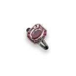 A ruby cluster ring, the oval-shaped ruby is set within a surround of tapered baguette-shaped rubies