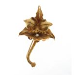 A gold orchid brooch, realistically designed and set with a seed pearl in yellow gold. 6.3cm long.