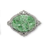 An early 20th century jade and diamond brooch, the carved oval jade plaque, within scallop-edged