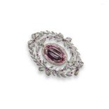 A Belle Epoque pink topaz and diamond brooch, the oval-shaped pink topaz is set within a