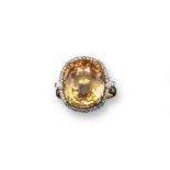 An unusual hessonite garnet and diamond set gold ring, the oval-shaped garnet weights