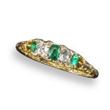 A late Victorian small emerald and diamond half hoop ring, set with three emeralds and two cushion-
