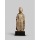 A CHINESE LIMESTONE FIGURE OF BUDDHA PROBABLY EASTERN WEI DYNASTY Standing with downcast eyes,