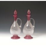 A pair of glass claret jugs and stoppers 19th century, the ovoid bodies engraved with hunting scenes