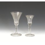 Two large wine glasses mid 18th century, with bell bowls, the smaller raised on a plain stem, the