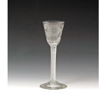 A wine glass of Jacobite significance c.1760, the rounded funnel bowl engraved with a six-petalled