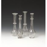 Four glass toddy lifters 19th century, with bulbous bodies rising to long slender necks with ring