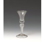A wine glass mid 18th century, with bell-shaped bowl raised on a baluster airtwist stem, the base of