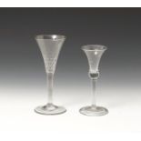 Two wine glasses 2nd half 18th century, one with a small bell bowl, the other with a drawn trumpet
