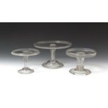 Three glass tazzae or syllabub stands mid 18th century, the flat circular tops with a slight