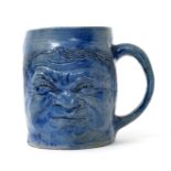 A Martin Brothers Face mug designed by Robert Wallace Martin, modelled and incised with a scowling
