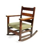 A Gustav Stickley oak rocking chair, with three slat backs, woven cane seat, 85cm. high Literature