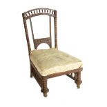 A Collinson & Lock low chair, with turned back and legs, the flaring back splats with carved