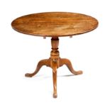 A George III oak tripod table, the circular tilt-top on a vase turned stem and cabriole legs, 63.5cm