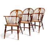 Three 19th century yew low back Windsor armchairs, each with a pierced splat back and an elm seat,