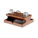 An early 19th century mahogany inkstand, with a brass handle, a pair of pen trays and two glass