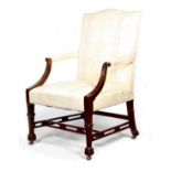 A George III mahogany Gainsborough armchair, upholstered in a cream damask fabric, with scroll