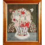 An early Victorian woolwork embroidered picture, of a still life of a basket of flowers, with two