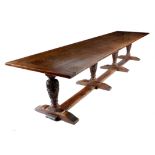 A large oak refectory dining table in 17th century style, the boarded top with cleated ends, on leaf