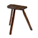 A primitive elm dairy stool, the underside of the seat branded with initials 'NB', on tripod
