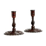 A pair of early 19th century mahogany turned candlesticks, each with fluted decoration, the circular