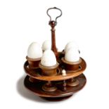 A Victorian treen turned lignum vitae egg cruet, with five associated walnut egg cups and with six