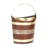 A 19th century mahogany and brass bound navette shape peat bucket, with a later brass liner and a