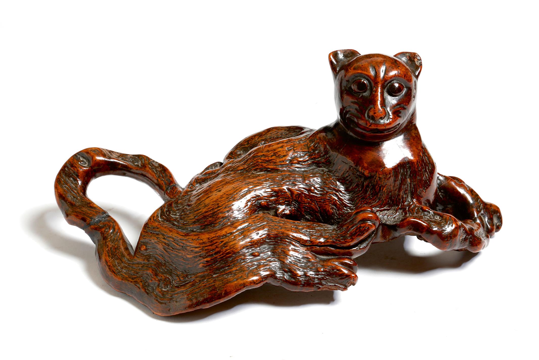 A Japanese rootwood carving of a recumbent cat, late 19th / early 20th century, 33cm long.