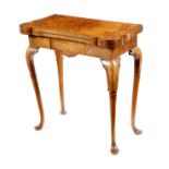 An early 18th century walnut and seaweed marquetry card table, the crossbanded fold-over top