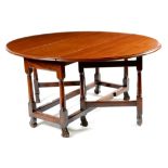 A walnut gateleg table, the oval drop-leaf top with a moulded edge, above a frieze drawer to one