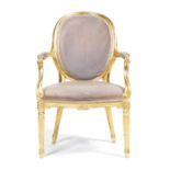 A giltwood open armchair in George III style, upholstered with plush fabric, with an oval back,