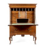 A George II oak cabinet on stand, the moulded cornice with a cushion drawer, above a fielded