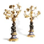 A pair of Napoleon III gilt and patinated bronze four-light figural candelabra, each modelled with a