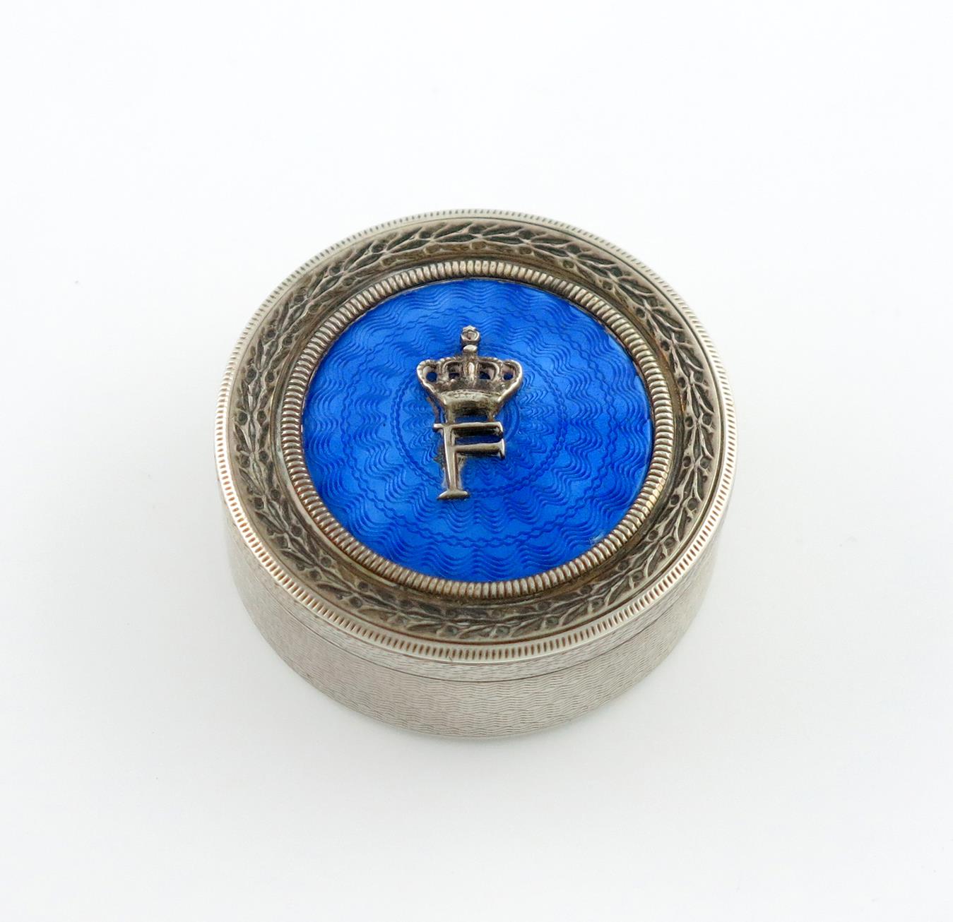 An Egyptian silver and enamel box, circular form, the pull-off cover with blue enamel and applied